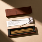Incense sticks in a box with a brand label on a beige background