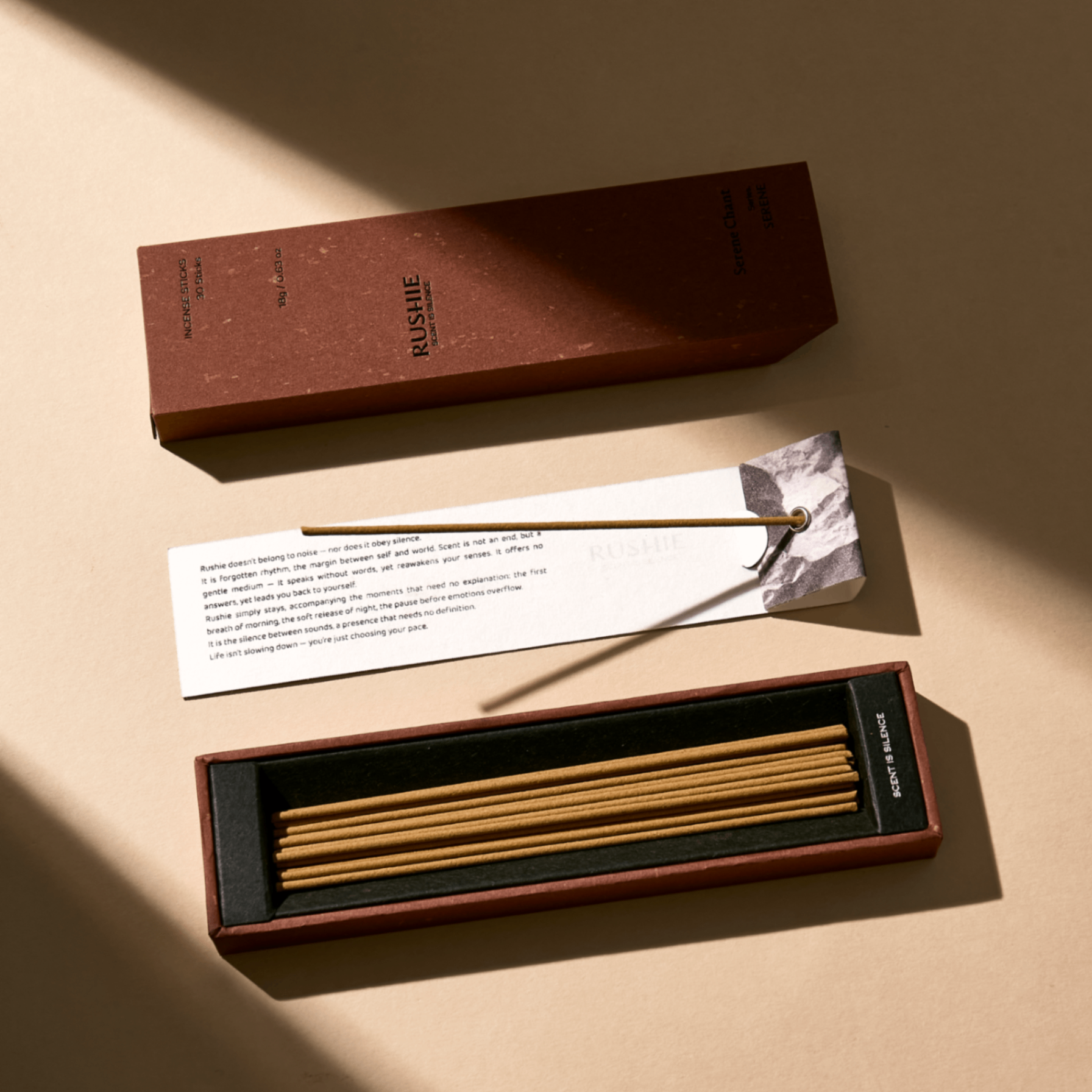 Incense sticks in a box with a brand label on a beige background