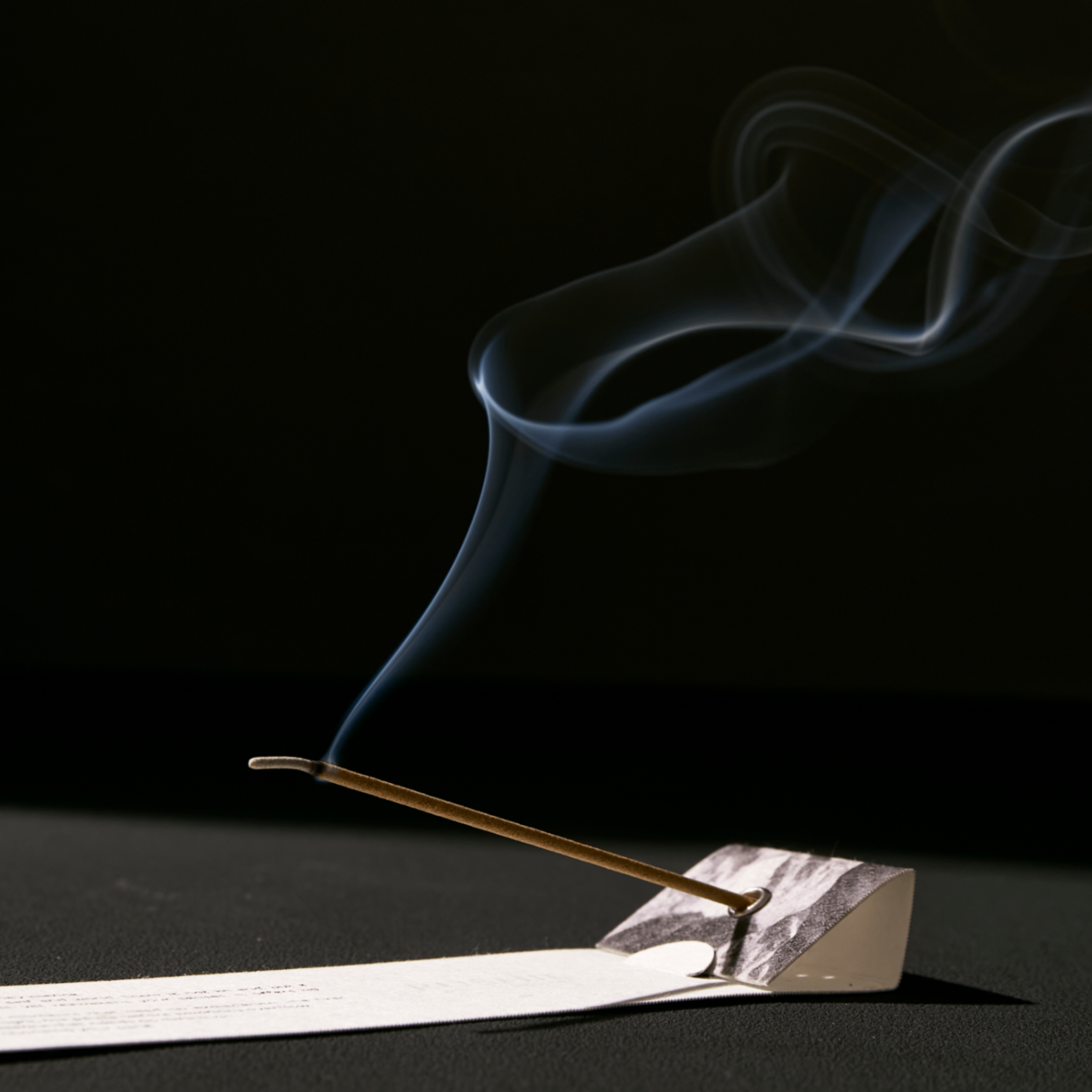 Incense stick with smoke on a black background